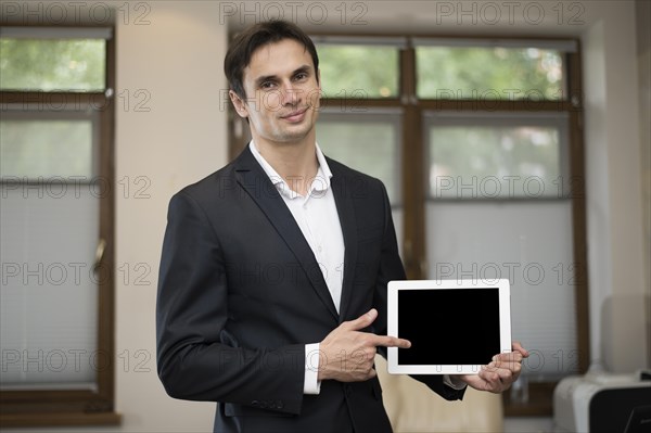 Medium shot businessman holding tablet