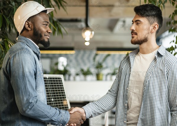 Medium shot man shaking hands indoors