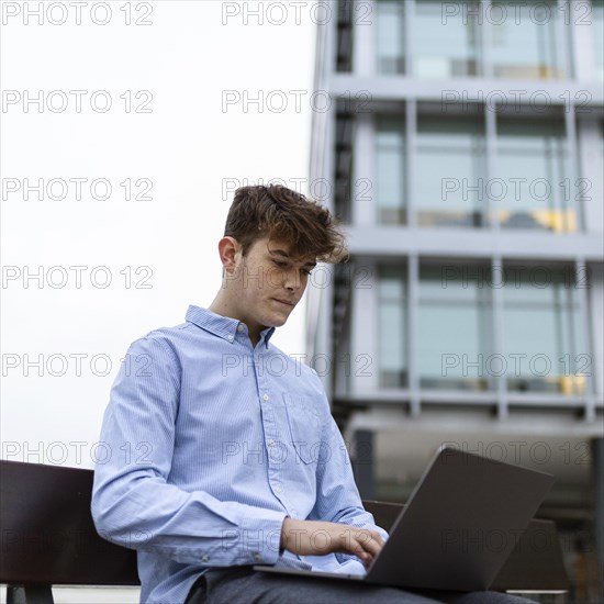 Medium shot boy working with laptop