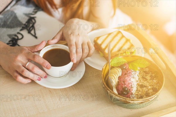 Close up woman s hand holding bowl oatmeal with fruits tray