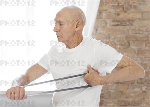 Medium shot senior man with elastic band