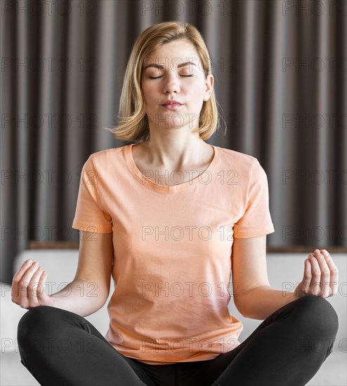 Medium shot woman meditating indoors