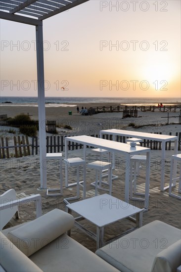 White tables and chairs in the sand