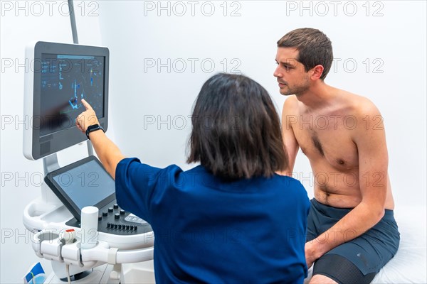 Patient sitting on stretcher while cardiologist performing a echocardiogram test in the hospital