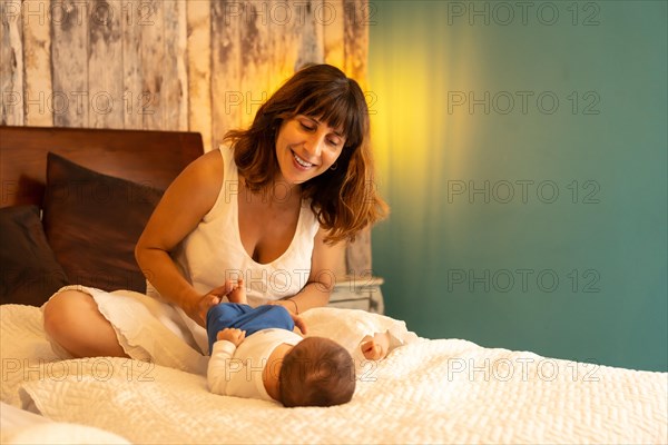 Happy mother and child lying on the bed in an hotel room