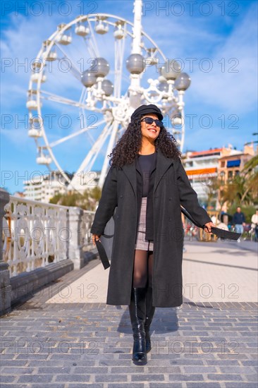 Vertical photo of a fashionable tourist enjoying a warm sunny day of winter in the city