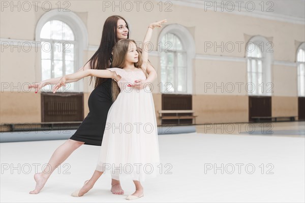 Girl ballerina teacher dancing together dance studio