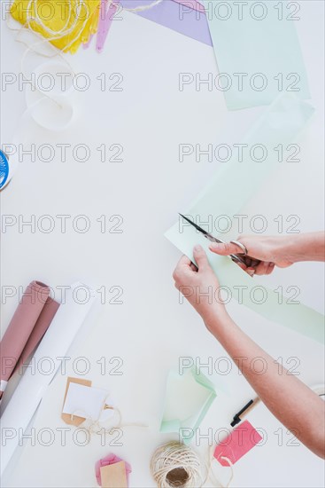 Close up woman cutting card paper with scissor