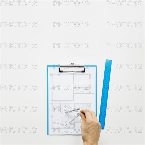 Human hand making blueprint using rounder white desk