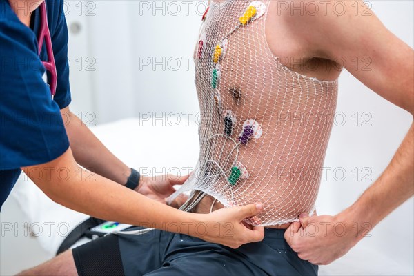 Close-up of the torso of a patient with attached electrodes getting ready for a cardiovascular stress test