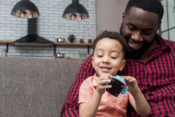 Black son father sitting with toy car