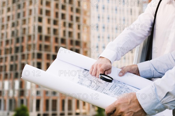 Close up people holding building sketch