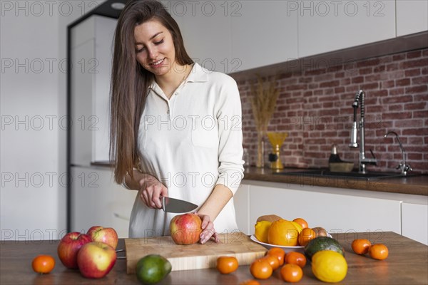 Medium shot woman cutting fruit