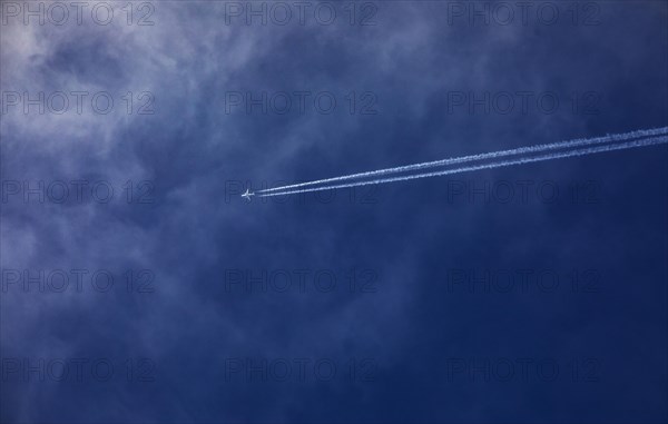 Commercial aircraft with contrails in the blue sky