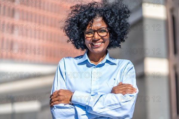 Portrait of an african businesswoman smiling and standing proud with arms crossed outside a financial building