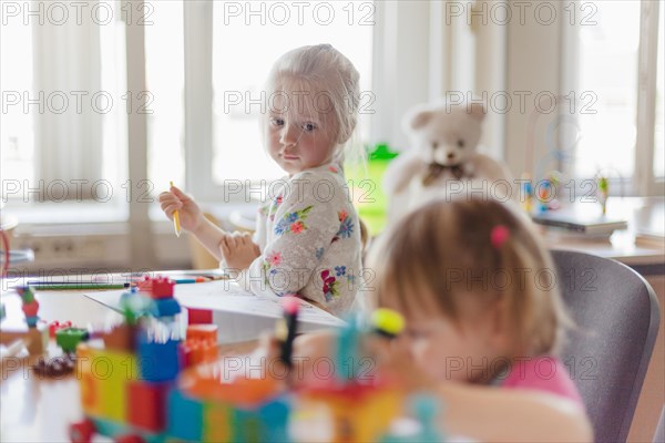 Little girl drawing sitting table