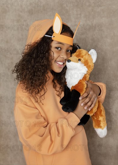 Medium shot girl holding fox toy