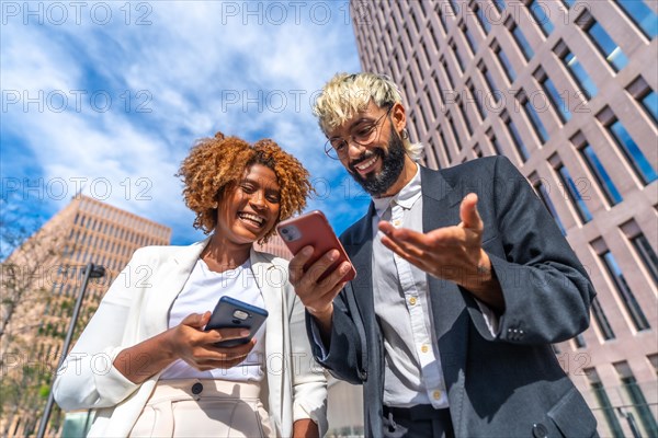 Low angle view portrait of happy multi-ethnic business people smiling while using phone outdoors