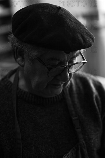 Portrait of senior violinmaker artisan luthier in workshop in Cremona