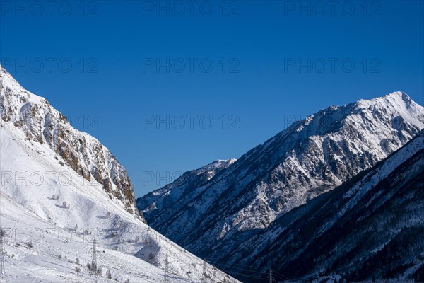 High voltage cable towers in the snowy mountains of the Pyrenees in France