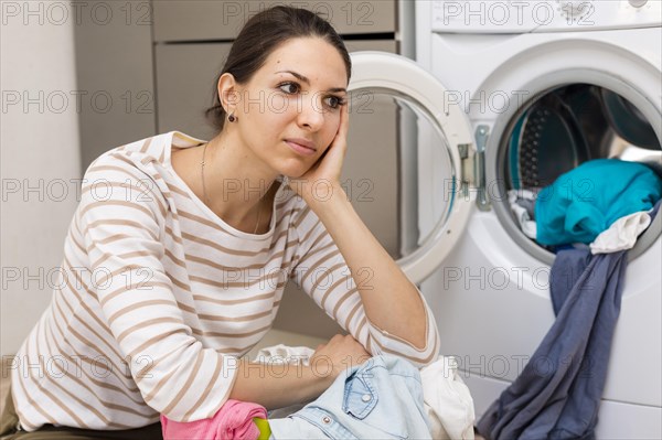 Tired woman doing laundry