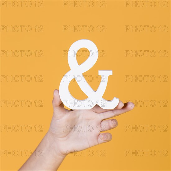 Woman s hand holding sign yellow background