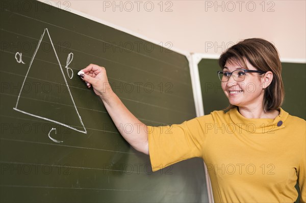 Low angle teacher writing chalkboard
