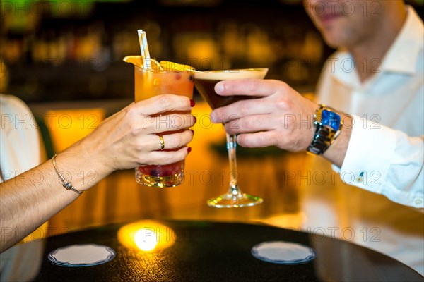 Close-up of a romantic couple toasting with cocktails in a luxury restaurant