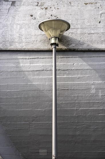 Street lamp in front of a concrete wall