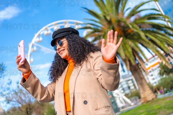 Woman posing while taking a selfie in the city during a warm day of winter