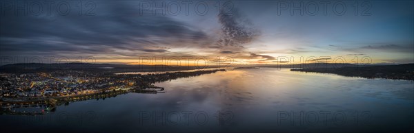 Aerial panorama of western Lake Constance in front of sunrise with the town of Radolfzell and the Mettnau peninsula