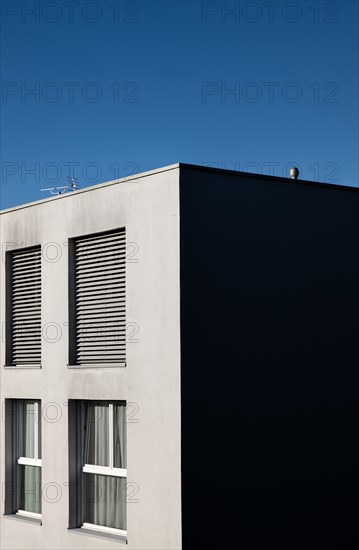 Modern Shape of a Corner on a Building with Windows Against Blue Clear Sky in a Sunny Day in Switzerland