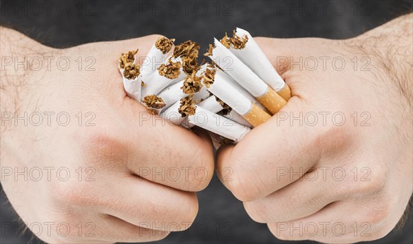 Close up hands breaking bundle cigarettes