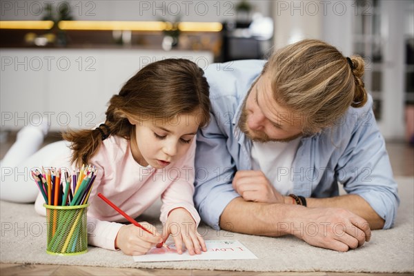 Front view little girl spending time with father drawing