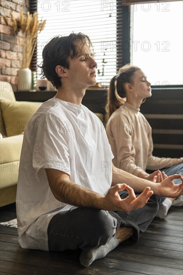 Full shot couple meditating together