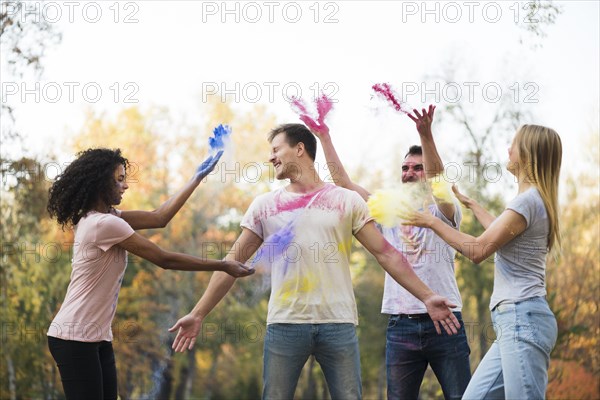 Group friends throwing powdered color air