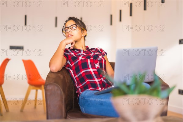 Freelance worker having ideas while working from home with laptop