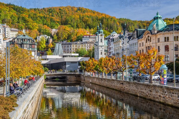 Tepla River in the town centre with the spa colonnade and the Church of St. Mary Magdalene in autumn