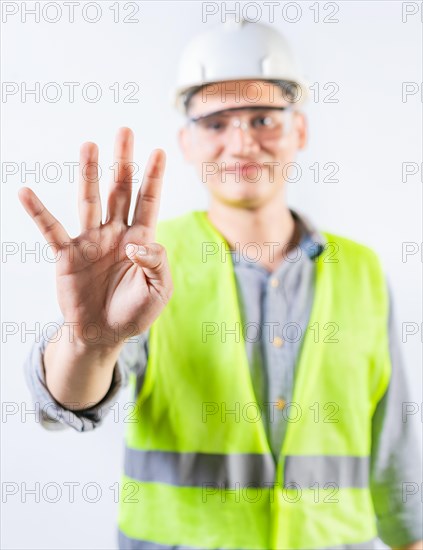 Young engineer counting number four isolated. Male engineer showing number four with fingers isolated