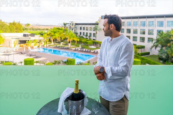 Man preparing a romantic toast with champagne in the hotel terrace