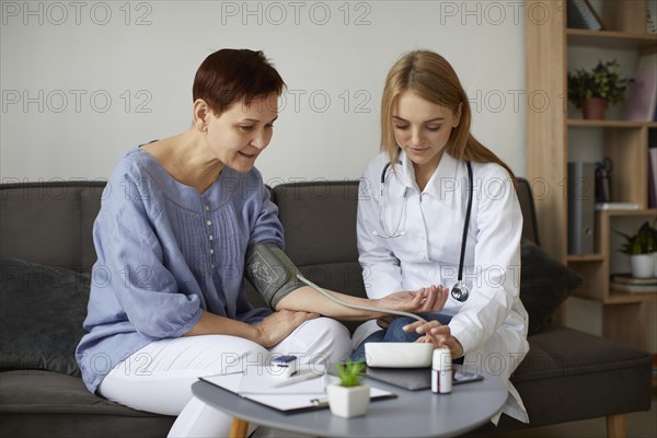 Covid recovery center female doctor checking elder patient s blood pressure