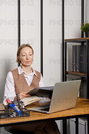 Young adult woman holding in hands binder folder with files