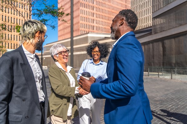 Relaxed multi-ethnic business people greeting in an outdoors meeting in the morning