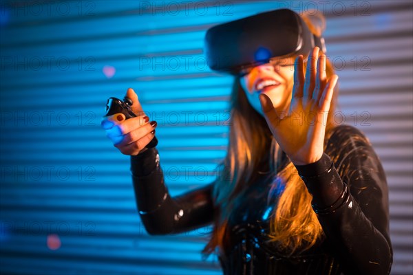 Smiling woman playing using virtual reality goggles at night