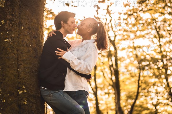 Rays of the sun illuminating a couple kissing in the forest