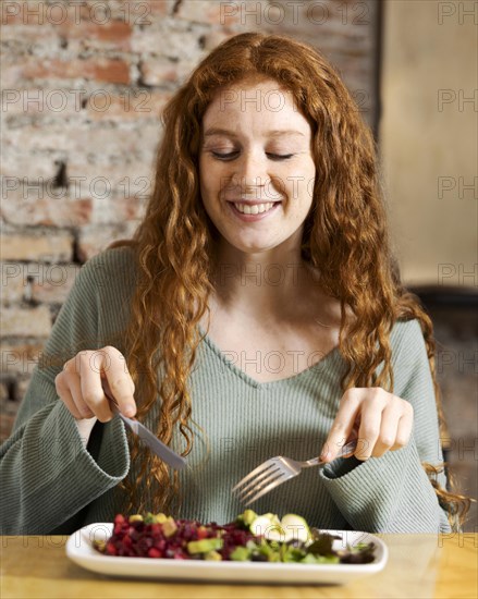 Medium shot smiley woman eating