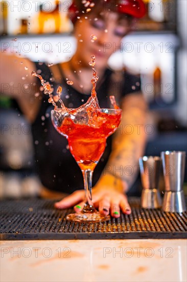 Vertical photo of a professional bartender preparing a Sex on the beach cocktail