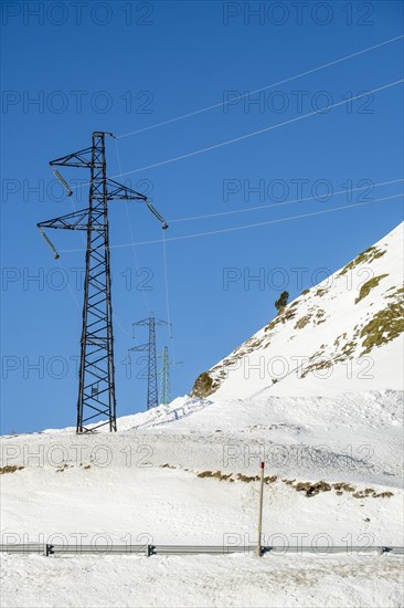 High voltage cable towers in the winter landscape with snow in the snowy mountains of the Pyrenees of Andorra