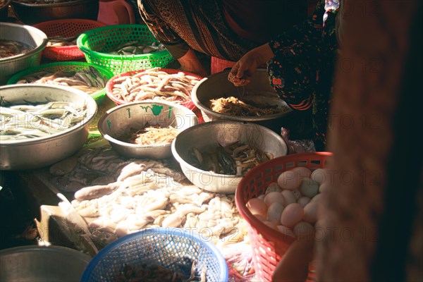 Vendor selling fresh seafood in the local traditional Samaki wet market in Kampot Cambodia