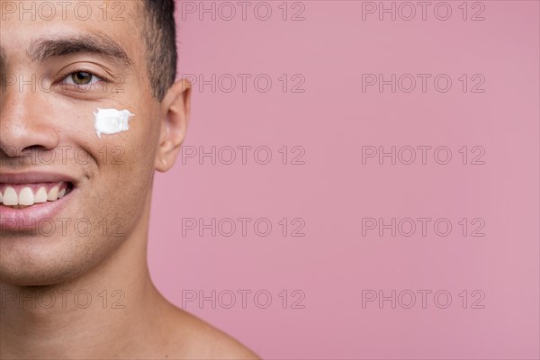 Front view smiley man with cream his face